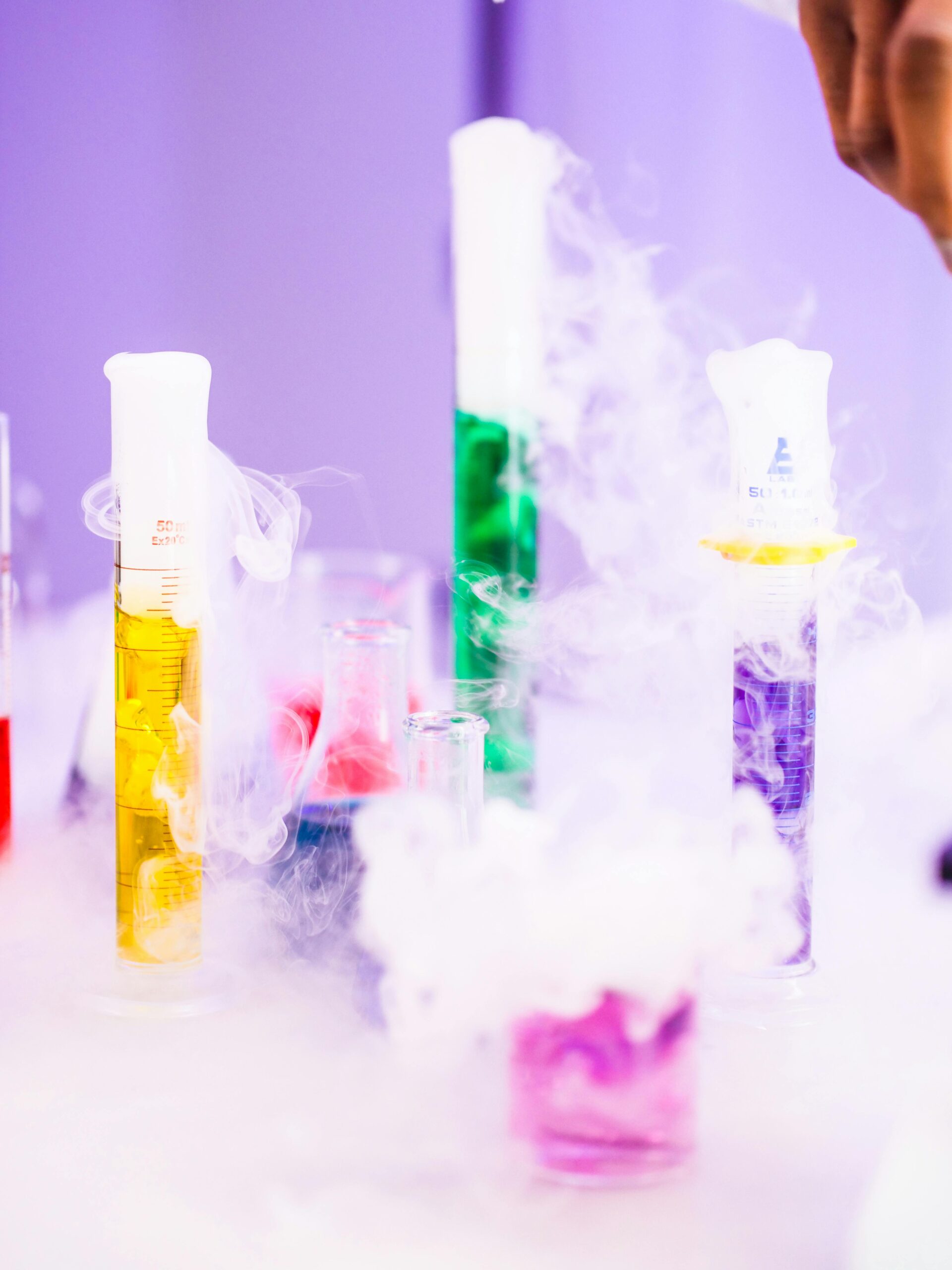 Colorful chemicals in laboratory glassware with smoke, depicting a vibrant scientific experiment.